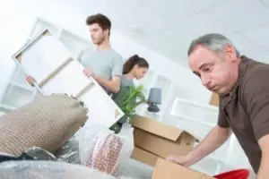 Family engaged in the process of unpacking and arranging items in a new home.